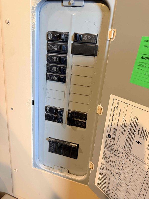 Conducted site visit to front portion of residential property to assess existing HVAC system for replacement estimate. Inspected and documented ductwork components in ceiling cavity, including insulated refrigerant lines with metallic wrap showing wear, flexible duct connections, and foam insulation at penetration points. Evaluated electrical circuit breaker panel capacity and available circuits to determine compatibility with new HVAC equipment installation requirements.