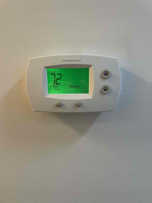 Responded to no cooling complaint on first seasonal startup where customer reported water discharge from unit. Arrived on site and performed system inspection. Thermostat verified in proper operating mode with system currently off. Outdoor condensing unit inspected and found in normal physical condition with no visible refrigerant leaks or component damage. Customer advised that another technician mentioned potential low refrigerant charge requiring further evaluation.