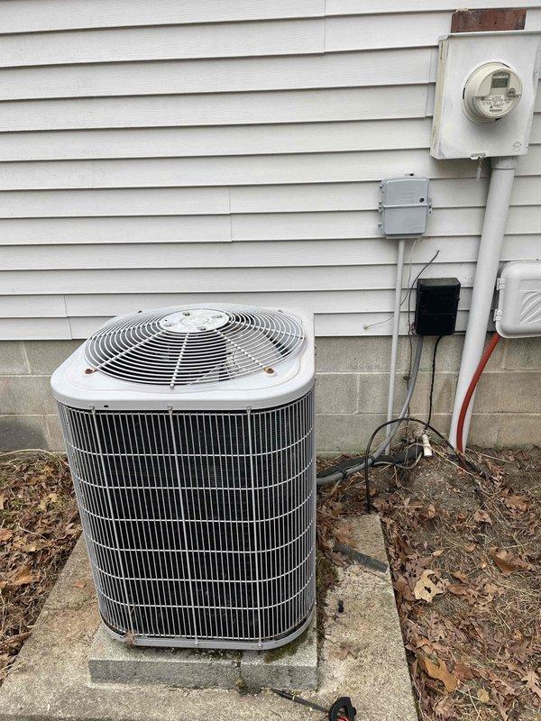 Responded to no cooling complaint on first seasonal startup where customer reported water discharge from unit. Arrived on site and performed system inspection. Thermostat verified in proper operating mode with system currently off. Outdoor condensing unit inspected and found in normal physical condition with no visible refrigerant leaks or component damage. Customer advised that another technician mentioned potential low refrigerant charge requiring further evaluation.