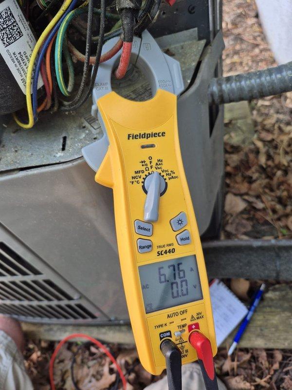 Completed scheduled cooling maintenance visit on residential HVAC system. Verified thermostat operation showing 71°F inside temperature with system following programmed schedule correctly. Performed electrical diagnostics using clamp meter at outdoor condensing unit, measuring amperage draw of 6.76 amps with system operating within normal parameters. All electrical connections at terminal block inspected and found secure with proper wire routing. System tested and confirmed cooling operation satisfactory.