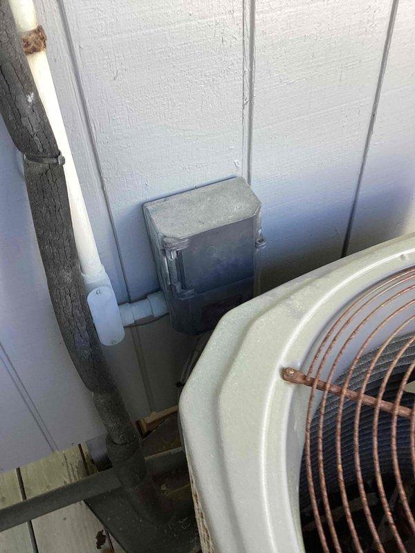 Responded to no cooling complaint on residential HVAC system. Upon arrival, inspected outdoor condenser unit and indoor air handler components. Found system operational issues requiring attention. Documented equipment condition with measurements showing 14.5-inch copper line extension, 22-inch unit width, and 21-inch clearance from wall to floor. Photographed outdoor condenser unit showing typical wear on copper coil grille and documented electrical disconnect box installation. Addressed cooling system malfunction and restored normal operation under existing service agreement terms.