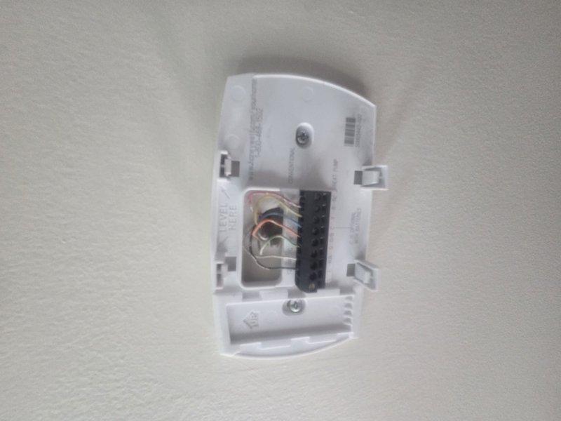 Performed routine HVAC maintenance and cooling system inspection. Accessed thermostat wiring to verify proper connections of all low-voltage control wires at terminal block, confirmed Honeywell digital thermostat displaying accurate temperature readings and responding appropriately to user inputs. System operational and ready for cooling season.