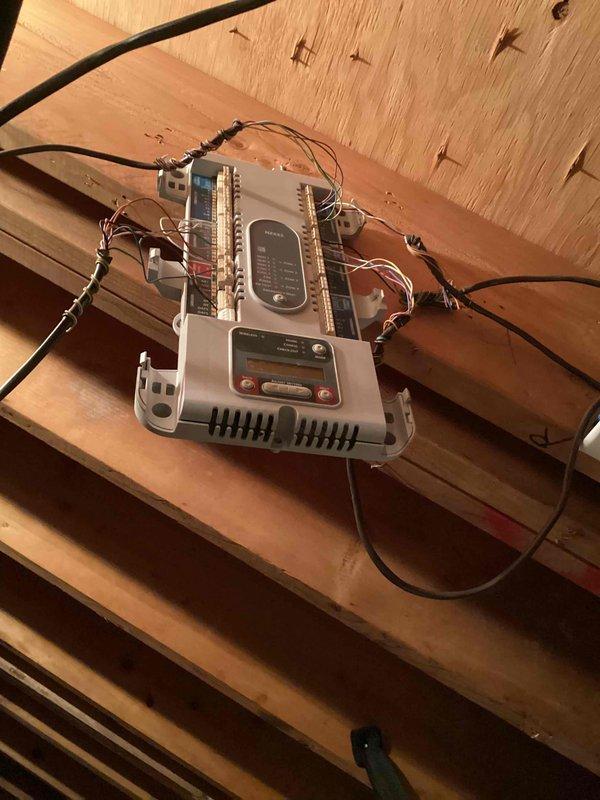 Responded to service call for outdoor unit making excessive noise and failure to heat. Upon inspection, diagnosed mechanical failure in outdoor unit compressor assembly. Documented existing ductwork configuration showing 22-inch and 30-inch flexible metallic ducts in attic space with multiple zone connections to air handling equipment. Verified control system wiring and thermostat connections at zone control panel mounted on ceiling joists, confirming proper electrical connections and communication between components. Restored heating operation to affected zone and verified system performance before departure.