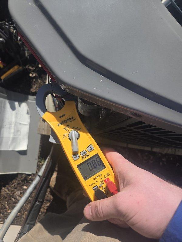 Completed preventive maintenance cooling system inspection on residential HVAC unit. Performed electrical diagnostics using clamp meter to verify amperage draw and system performance at outdoor condensing unit. Inspected refrigerant lines, condenser coil, and attic insulation conditions as part of comprehensive cooling season readiness check.