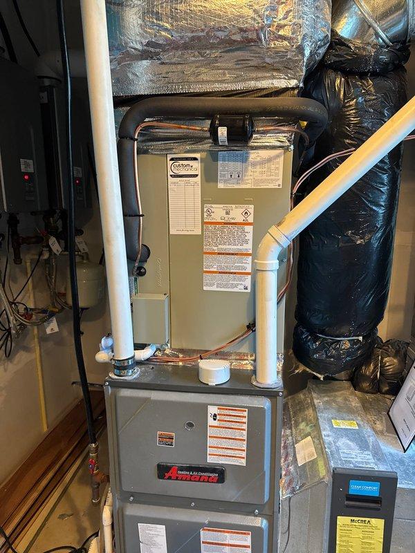 Removed and disposed of existing coil and heat pump system. Installed new 5A6H7048 17 SEER heat pump on pressure-treated wood platform with 5TXCC006 coil in utility room. Fabricated and installed custom transitions to adapt new air handler to existing trunk ductwork. Integrated system with existing damper controls and thermostat setup. Installed new electrical whip and disconnect for outdoor unit. Ran copper refrigerant lines from indoor coil to outdoor heat pump, then flushed, pressure tested, and charged refrigeration system to manufacturer specifications. All equipment operational and performing within normal parameters upon completion.