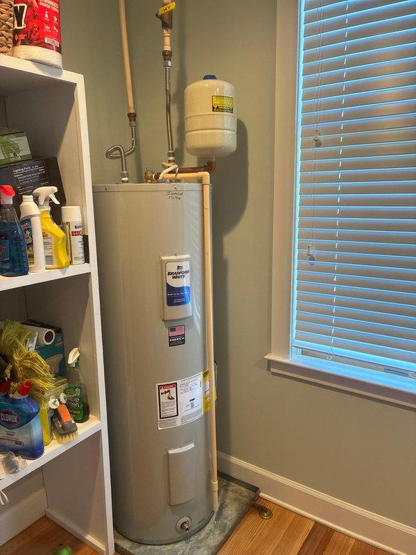 Completed installation of two 50-gallon tall electric water heaters (RE250T6) in residential utility room. Removed existing units and installed new water heaters on 22-inch aluminum drain pans to protect flooring from potential leaks. Connected water supply lines using 18-inch stainless steel flex connectors with 3/4-inch male transition unions for secure, code-compliant connections. Installed expansion tank on cold water supply line using 3/4-inch brass fittings including tee, 90-degree elbow, and nipples of appropriate lengths to properly position tank and accommodate thermal expansion. Verified all electrical connections to 240V power supply were secure and properly terminated. Tested both units for proper operation, checked all plumbing connections for leaks, and confirmed adequate water pressure and temperature settings. Installation required two technicians and approximately four hours to complete. All work performed in accordance with local plumbing codes and manufacturer specif