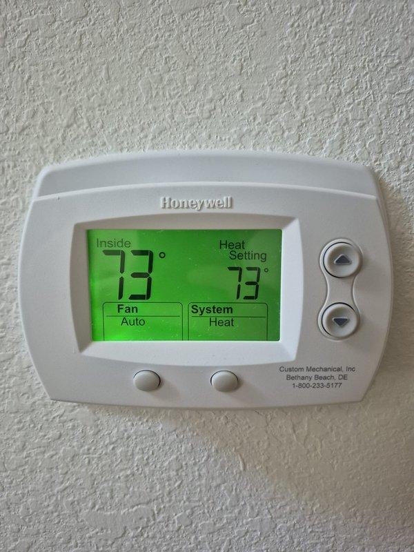 Completed preventive maintenance cooling visit on residential HVAC system. Verified thermostat operation showing 73°F indoor temperature with system in heating mode. Performed electrical diagnostics on outdoor unit using clamp meter, recording voltage and amperage readings to confirm proper system operation and component functionality.