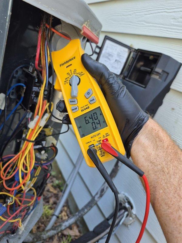 Completed preventive maintenance cooling visit on residential HVAC system. Verified thermostat operation showing 73°F indoor temperature with system in heating mode. Performed electrical diagnostics on outdoor unit using clamp meter, recording voltage and amperage readings to confirm proper system operation and component functionality.