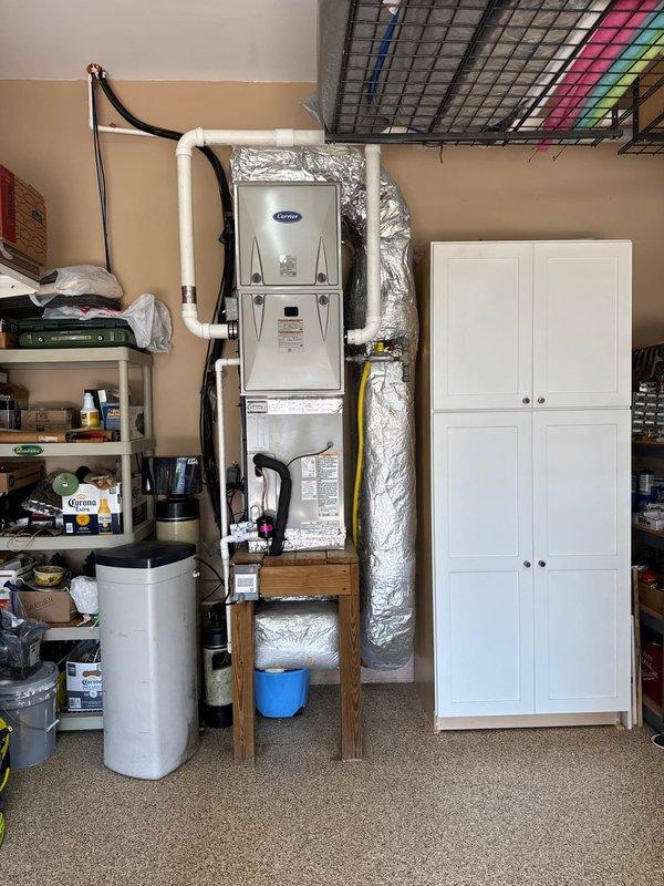 Completed full HVAC system replacement on first floor, removing and disposing of existing equipment. Installed Carrier 59TP7B060V17 two-stage variable speed furnace with CAAMP3017 evaporator coil in garage utility space, mounted vertically on wall platform. Installed 27SCA530 2.5-ton heat pump outdoor unit on existing concrete pad with new electrical whip and disconnect. Flushed existing refrigeration lines, performed pressure test to verify system integrity, and recharged system to manufacturer specifications. Installed Honeywell T10 dual-fuel heat pump thermostat for coordinated control of heat pump and gas furnace operation. All ductwork connections secured with reflective insulation wrap. System commissioned and tested for proper operation across all stages. Installation includes comprehensive one-year warranty coverage on all equipment and labor for entire house HVAC system.