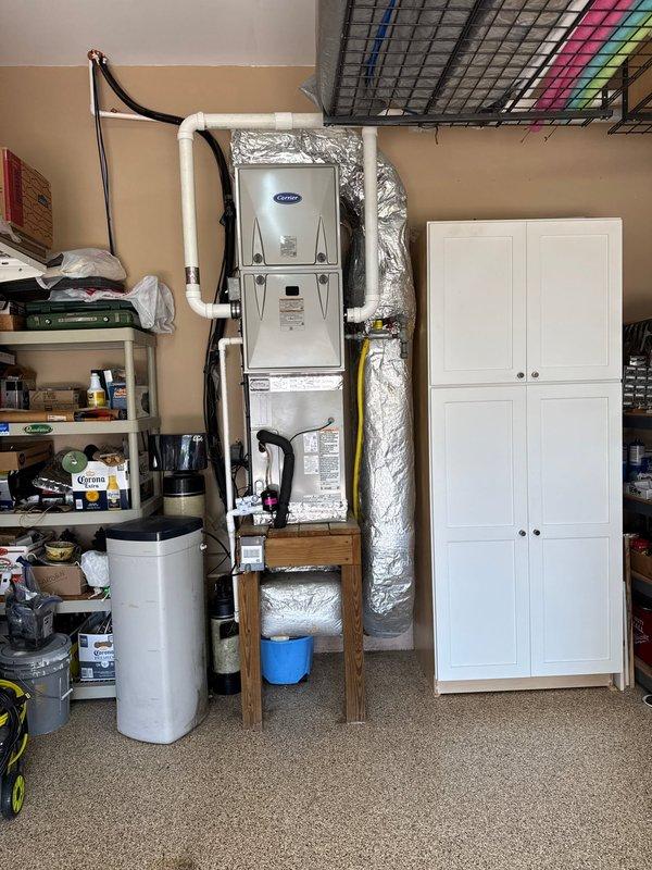 Completed full HVAC system replacement on first floor, removing and disposing of existing equipment. Installed Carrier 59TP7B060V17 two-stage variable speed furnace with CAAMP3017 evaporator coil in garage utility space, mounted vertically on wall platform. Installed 27SCA530 2.5-ton heat pump outdoor unit on existing concrete pad with new electrical whip and disconnect. Flushed existing refrigeration lines, performed pressure test to verify system integrity, and recharged system to manufacturer specifications. Installed Honeywell T10 dual-fuel heat pump thermostat for coordinated control of heat pump and gas furnace operation. All ductwork connections secured with reflective insulation wrap. System commissioned and tested for proper operation across all stages. Installation includes comprehensive one-year warranty coverage on all equipment and labor for entire house HVAC system.