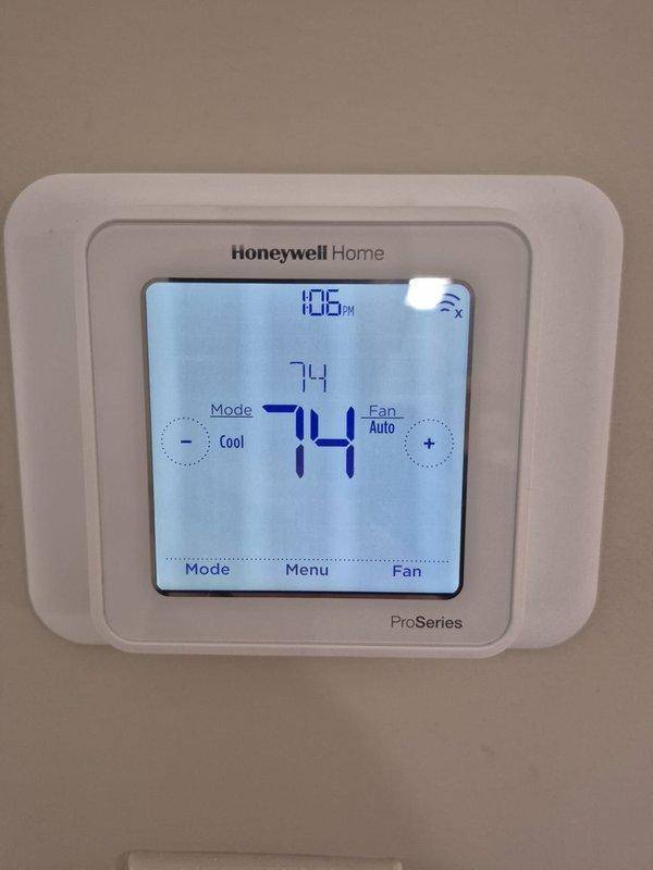 Completed routine cooling maintenance visit on HVAC system. Performed electrical diagnostics using clamp meter to verify amperage readings on outdoor unit components, confirmed proper operation of compressor and condenser fan motor. Verified thermostat functionality with Honeywell ProSeries unit displaying 74°F ambient temperature in cooling mode with auto fan setting, system maintaining setpoint accurately at time of service.