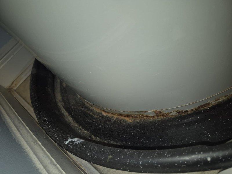 Responded to service call for water heater not maintaining hot water and malfunctioning garbage disposal. Inspected water heater unit and found sediment buildup affecting heating efficiency. Flushed water heater tank to remove mineral deposits and tested heating element functionality. Examined garbage disposal unit and identified worn rubber gasket with visible deterioration, mold accumulation, and rust discoloration at seal interface. Recommended replacement of disposal gasket to restore proper operation and prevent leaks. Verified water heater restored to normal operating temperature and documented equipment condition with photographs for service records.