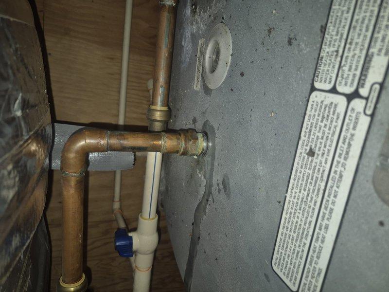 Responded to service call for water leak investigation at residential property. Located and identified pinhole leak at top connection point of water heater where copper piping connects to unit with brass fittings. Additionally inspected upstairs bathroom shower and confirmed active dripping leak requiring repair. Documented both leak locations with photographs for customer records and repair recommendations.
