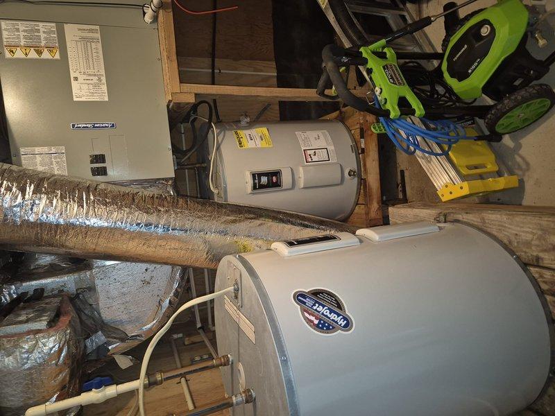 Responded to service call for water leak investigation at residential property. Located and identified pinhole leak at top connection point of water heater where copper piping connects to unit with brass fittings. Additionally inspected upstairs bathroom shower and confirmed active dripping leak requiring repair. Documented both leak locations with photographs for customer records and repair recommendations.