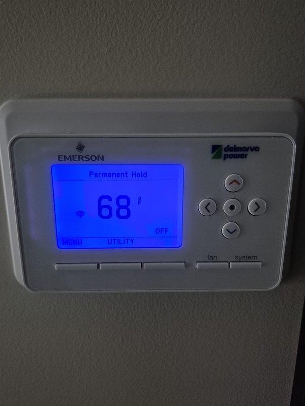 Completed preventative maintenance cooling visit on first of two HVAC systems. Performed electrical diagnostics using digital multimeter, verifying voltage readings at control board and confirming proper operation of relay switches and wiring connections within the electrical cabinet. Checked thermostat functionality, confirmed unit responding correctly to temperature settings with system currently in permanent hold mode at 68°F with heating/cooling system in OFF position.