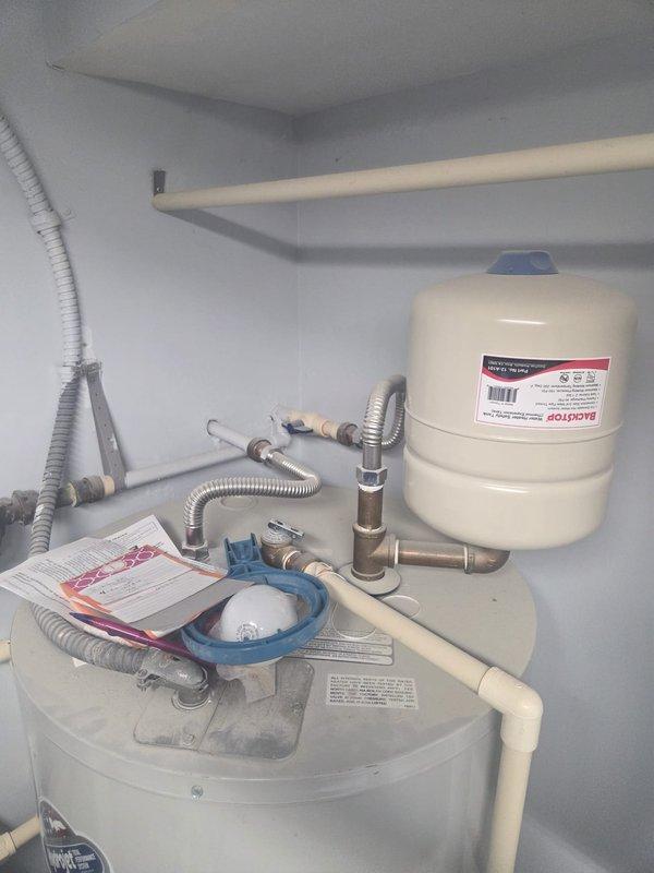 Completed scheduled cooling maintenance visit on residential HVAC system. Inspected outdoor condenser unit mounted on wooden platform, verified proper operation and clearances, and documented water heater and expansion tank configuration in mechanical closet with associated plumbing connections. All cooling system components found operating within normal parameters.