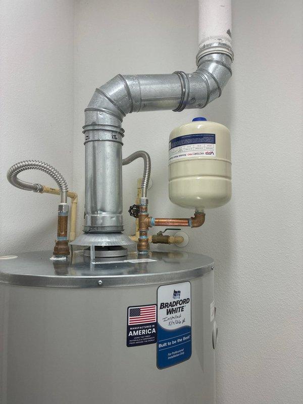 Completed installation of 75-gallon Bradford White gas water heater model RG275H6X1. Installed 28-inch drain pan beneath unit for leak protection and mounted thermal expansion tank to accommodate system pressure fluctuations. Connected hot and cold water supply lines using 18-inch flexible stainless steel connectors with 3/4-inch brass fittings, including brass nipples, 90-degree elbow, and tee connections as required for proper water flow configuration. Installed temperature and pressure relief valve with appropriate discharge piping. Connected gas supply line to burner assembly and verified all connections for proper operation. Configured galvanized steel venting system with multiple elbows to ensure proper exhaust ventilation. Tested all water connections for leaks, verified gas connections for safety, and confirmed unit functionality. Shut off water supply per owner's request upon completion of installation.