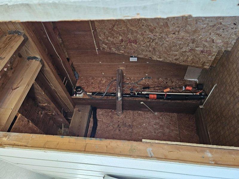 Conducted site assessment at residential construction project to evaluate refrigerant line relocation requirements. Inspected exterior wall penetrations and attic access areas to determine optimal routing for HVAC refrigerant piping. Documented existing building conditions including exposed framing, OSB sheathing, and current utility penetrations to develop relocation plan that accommodates ongoing construction schedule and building envelope requirements.