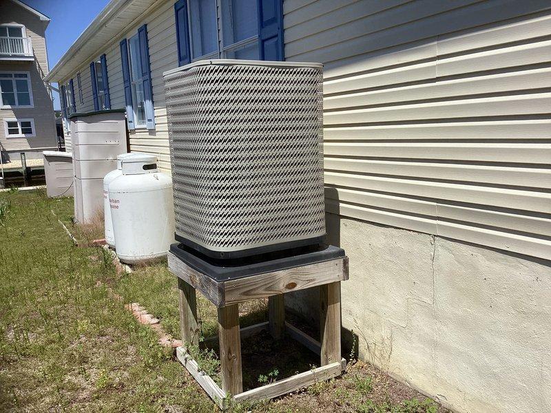 Provided estimate for complete dual fuel heat pump system replacement after diagnosing failed compressor in existing outdoor unit. Assessed current installation including aged condenser unit mounted on weathered wooden platform with drainage pan, reviewed electrical panel configuration, and documented system specifications to prepare comprehensive replacement proposal for customer consideration.