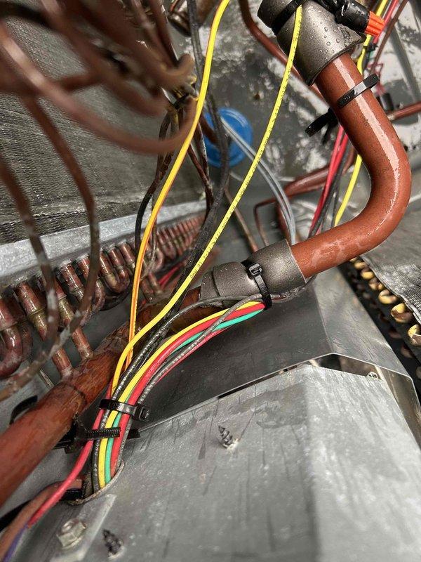 Responded to no cooling call on 10+ year old HVAC system. Upon inspection, found unit inoperative with visible moisture on copper refrigerant lines and aged components showing oxidation and wear. Performed diagnostic evaluation of electrical connections, refrigerant piping, and blower assembly to identify failure points. Documented system condition with photos showing copper tubing, wiring harness, heat exchanger coils, and internal mechanical components for service records and potential system replacement discussion.