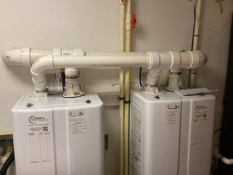 Completed installation of two Navien tankless water heaters in a side-by-side configuration in the utility room. Units were wall-mounted and connected with white PVC venting systems running horizontally between both heaters with proper elbow joints and vertical exhaust terminations. Yellow CSST gas lines were installed and secured with appropriate supports to supply both units, with all gas connections properly made and tested. Water supply piping was completed using a combination of PEX and copper connections, including isolation valves for service access. Electrical wiring was run and terminated at both units to provide power to the digital control panels. All manufacturer specifications were followed for proper clearances, venting requirements, and installation guidelines. System was pressure tested, fired up, and verified for proper operation on both units.