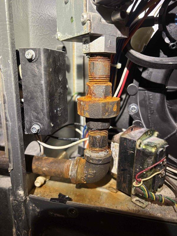 Responded to home inspection concern regarding possible condensation leak or inadequate drainage at air handler located in upstairs storage room. Upon arrival, conducted thorough inspection of unit and surrounding area. Found significant rust and corrosion on condensate drain piping and fittings, indicating prolonged moisture exposure. Inspected drain pan, drain line connections, and trap assembly for proper function and blockages. Documented existing conditions with photos showing deteriorated pipe assembly and corroded components. Verified condensate drainage system operation and identified areas requiring attention. Communicated findings and recommendations to homeowner as requested.