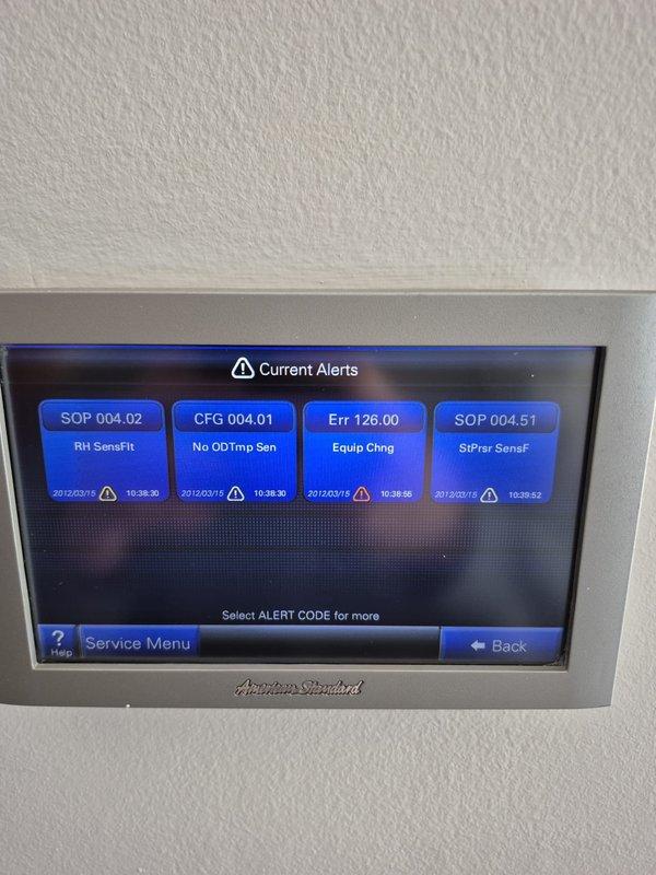Responded to no cooling call on American Standard system with thermostat displaying dealer alert. Found multiple system alerts on thermostat including outdoor temperature sensor configuration error (CFG 004.01), relative humidity sensor fault (SOP 004.02), equipment change error (Err 126.00), and static pressure sensor fault (SOP 004.51). Diagnosed primary issue as missing or improperly configured outdoor temperature sensor preventing system operation, addressed sensor configuration in advanced installer settings to restore cooling functionality.