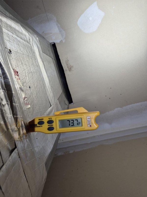 # HVAC Service Call - No Cooling Issue

Responded to service call for air conditioning system running continuously without achieving desired cooling. Upon arrival, found thermostat set to 73°F with indoor temperature reading 76°F and rising. Verified complaint that system had been running constantly with no temperature reduction.

Performed initial diagnostic assessment at thermostat location. Confirmed thermostat display showed "Cool On" mode with fan set to auto operation. Verified thermostat was calling for cooling and communicating properly with HVAC system. Used digital temperature measurement device to confirm ambient temperature readings matched thermostat display at 73.3°F in the conditioned space.

Inspected indoor air handler components and ductwork in mechanical area. Observed supply duct insulation and verified airflow from system. Documented current operating conditions with temperature measurements and thermostat settings for service records.

System evaluation revealed u