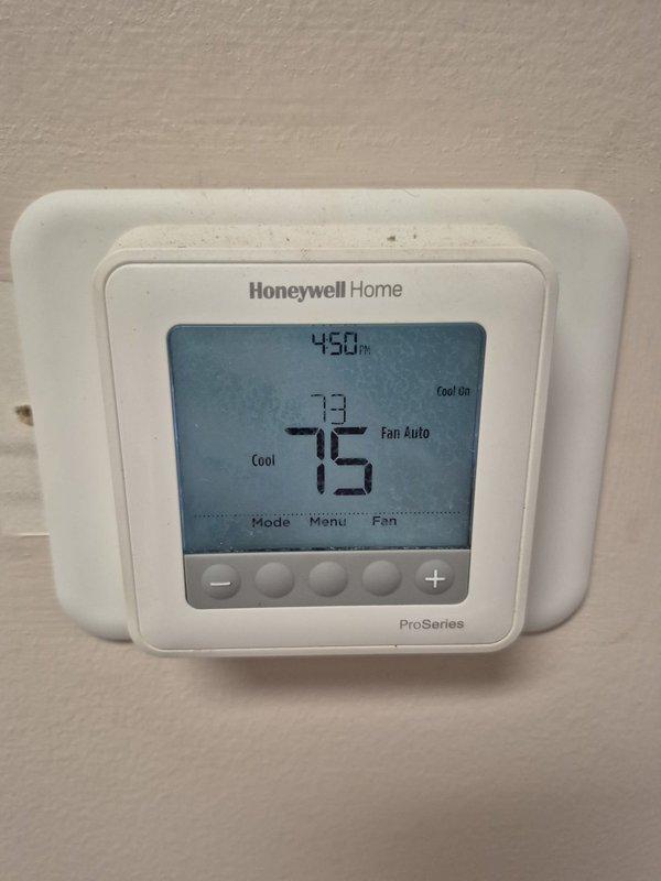 # HVAC Service Call - No Cooling Issue

Responded to service call for air conditioning system running continuously without achieving desired cooling. Upon arrival, found thermostat set to 73°F with indoor temperature reading 76°F and rising. Verified complaint that system had been running constantly with no temperature reduction.

Performed initial diagnostic assessment at thermostat location. Confirmed thermostat display showed "Cool On" mode with fan set to auto operation. Verified thermostat was calling for cooling and communicating properly with HVAC system. Used digital temperature measurement device to confirm ambient temperature readings matched thermostat display at 73.3°F in the conditioned space.

Inspected indoor air handler components and ductwork in mechanical area. Observed supply duct insulation and verified airflow from system. Documented current operating conditions with temperature measurements and thermostat settings for service records.

System evaluation revealed u