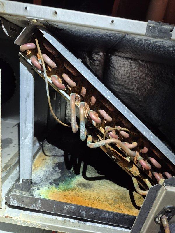 Completed HVAC system evaluation and provided estimate for boiler replacement. Inspection revealed heavily corroded evaporator coil with significant oxidation and discoloration throughout copper tubing, along with mineral deposits in drain pan indicating long-term moisture exposure and diminished system efficiency. Documented existing Honeywell thermostat currently operating in cooling mode with 4-degree temperature differential, confirming active system operation during assessment.