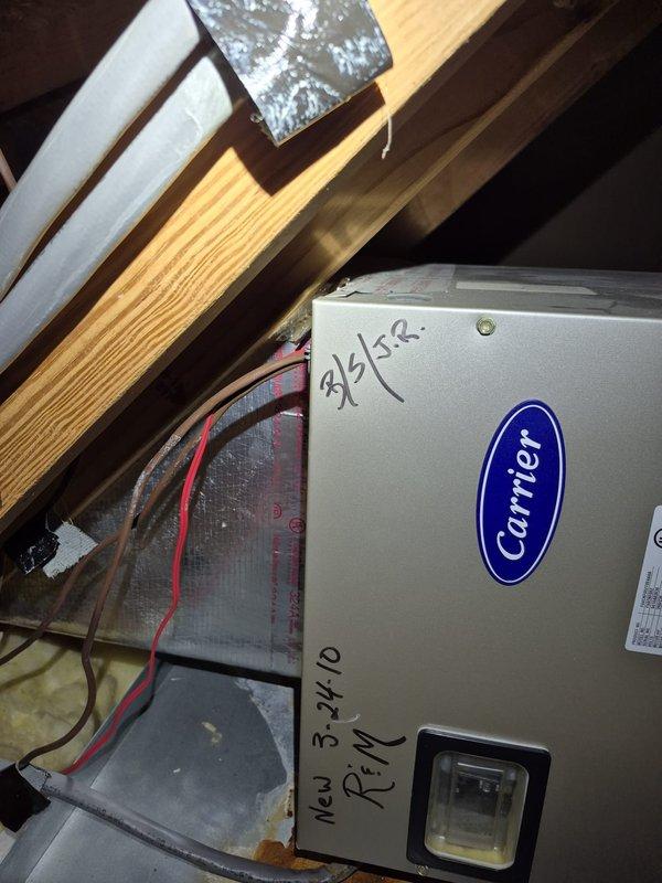 # HVAC Service Call - No Cooling Issue

Responded to no cooling complaint on Carrier air handler system located in attic space. Upon arrival, performed diagnostic evaluation of unit and surrounding components. Inspected air handler casing, electrical connections, and ductwork for proper operation and any visible defects. Red electrical wiring and control connections were examined for continuity and proper voltage. 

Evaluated refrigerant lines with blue foam insulation and verified secure mounting. Checked air filter housing and ductwork connections for proper airflow and sealing. Assessed attic installation conditions including clearances and ventilation. System was tested and restored to proper cooling operation. All components functioning within manufacturer specifications at time of departure.