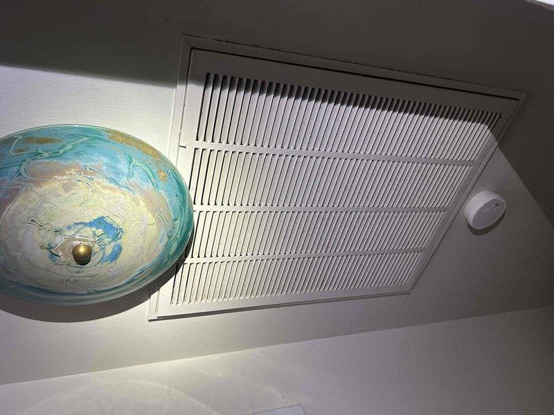 Responded to no cooling complaint for upstairs zone not maintaining set temperature. Accessed attic-mounted air handler to diagnose system performance issue. Inspected HVAC equipment, ductwork connections, and return air pathway. Documented existing system conditions including air handler installation, flexible duct routing, and return air grille configuration for 10+ year old system requiring further evaluation of cooling capacity and airflow distribution.