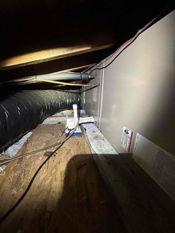 Responded to no cooling complaint for upstairs zone not maintaining set temperature. Accessed attic-mounted air handler to diagnose system performance issue. Inspected HVAC equipment, ductwork connections, and return air pathway. Documented existing system conditions including air handler installation, flexible duct routing, and return air grille configuration for 10+ year old system requiring further evaluation of cooling capacity and airflow distribution.