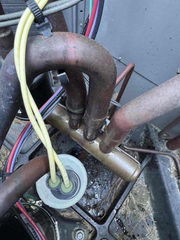 Completed cooling maintenance visit for multi-system HVAC installation with focus on top floor unit experiencing performance issues. Inspected refrigerant line connections, electrical components including capacitor and control wiring, and verified proper clearances and system specifications. Documented equipment condition showing oxidation on copper piping and assessed overall system operation to address cooling struggles on upper level.