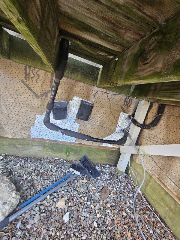 Responded to no cooling complaint on lower HVAC unit. Upon arrival, found system running with blower operational but not producing cool air. Inspected outdoor condensing unit located beneath deck structure, verified electrical connections and power supply to equipment, and documented installation conditions with photos for service records.