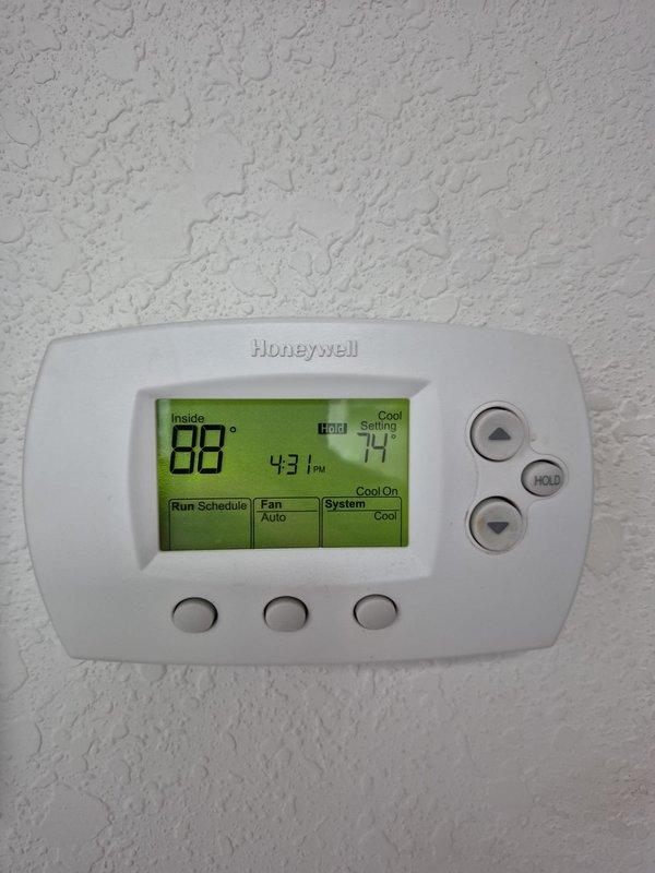 # HVAC No Cool Service Call

Responded to after-hours no cooling complaint. Upon arrival, found thermostat displaying 88°F inside temperature with cooling system activated but not achieving 74°F setpoint. Inspected outdoor condensing unit and identified failed dual-run capacitor showing visible signs of deterioration, corrosion on terminals, and discoloration from heat exposure. The JARD brand capacitor rated at 45+7.5μF was no longer providing adequate electrical support for compressor and condenser fan motor operation. Replaced defective capacitor with new unit matching original specifications. Verified proper electrical connections on all three terminals (compressor, fan, and common). Cycled system on and tested operation. Confirmed compressor and outdoor fan motor starting properly with normal amperage draw. System cooling normally and maintaining setpoint at time of departure. Unit returned to full operational status.
