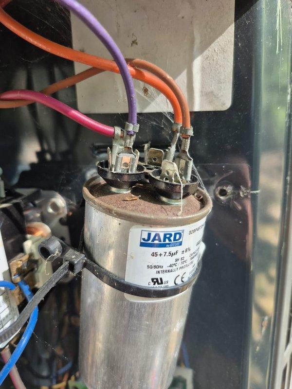 # HVAC No Cool Service Call

Responded to after-hours no cooling complaint. Upon arrival, found thermostat displaying 88°F inside temperature with cooling system activated but not achieving 74°F setpoint. Inspected outdoor condensing unit and identified failed dual-run capacitor showing visible signs of deterioration, corrosion on terminals, and discoloration from heat exposure. The JARD brand capacitor rated at 45+7.5μF was no longer providing adequate electrical support for compressor and condenser fan motor operation. Replaced defective capacitor with new unit matching original specifications. Verified proper electrical connections on all three terminals (compressor, fan, and common). Cycled system on and tested operation. Confirmed compressor and outdoor fan motor starting properly with normal amperage draw. System cooling normally and maintaining setpoint at time of departure. Unit returned to full operational status.