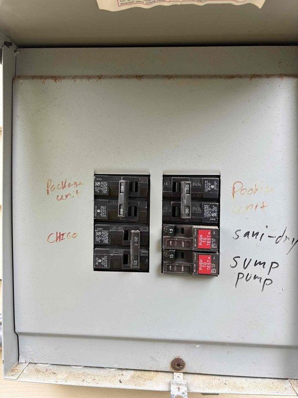 Responded to no cooling complaint on downstairs system. Accessed property through side entrance per instructions and located unit in basement area. Upon inspection, found system running but not cooling to desired temperature. Performed diagnostic testing using refrigerant manifold gauges to measure system pressures and temperatures across the evaporator coil. Readings indicated abnormal operating conditions with suction and discharge pressures outside normal parameters. Inspected electrical panel serving HVAC equipment, noting age-related deterioration with rust staining and multiple handwritten circuit identifications. Documented system conditions with photos of breaker panel and diagnostic gauge readings for service records. Advised that repair costs would be customer responsibility as unit age exceeds warranty coverage period, even with platinum level service agreement.