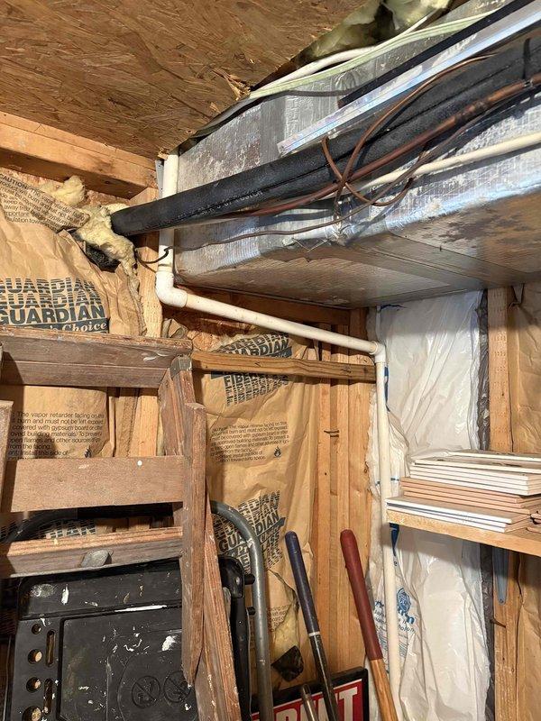 Performed preventive maintenance and indoor air quality inspection on HVAC system in elevated structure with crawl space access. Customer reported dampness concerns around equipment area prior to summer rental season. Conducted thorough system evaluation including visual inspection of ductwork, refrigerant lines, and insulation in attic/crawl space area. Examined HVAC installation showing rectangular metallic ductwork with reflective silver insulation, black foam insulation tubing, and copper refrigerant lines properly bundled. Assessed moisture conditions in vicinity of equipment and surrounding structural areas. Inspected exterior equipment storage and deck areas for potential water intrusion sources that could affect indoor air quality. Verified proper insulation placement including fiberglass batts between framing members. System found to be operating within normal parameters with no immediate concerns identified requiring corrective action at time of inspection.