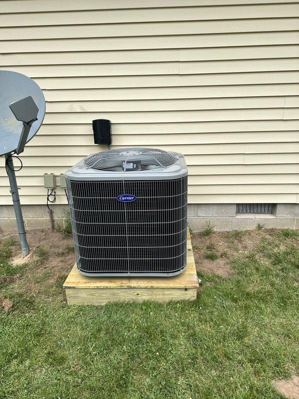 Completed full HVAC system replacement including removal and disposal of existing equipment. Installed new Carrier 27SCA542A003 3.5-ton 15 SEER heat pump on pressure-treated wood platform, Carrier FJ5ANXC48L00 air handler with Carrier FF3101C15 15kW electric heat pack, and Honeywell digital WiFi thermostat. Fabricated and installed metal duct transitions to adapt new equipment to existing ductwork. Replaced outdoor disconnect and electrical whip while reusing existing electrical service, condensation drain lines, and power lines. Positioned outdoor unit on elevated wooden platform for proper drainage and equipment protection. Verified all electrical connections, refrigerant charge, airflow, and system operation. System tested and confirmed operational with one-year parts and labor warranty from installation date.