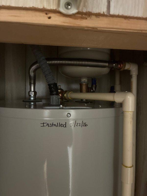 Replaced a 50-gallon tall electric water heater in a third-floor condo back bedroom closet. Installed new Bradford White unit with aluminum drain pan, expansion tank, brass fittings including T and 90-degree elbow, brass nipples, 18-inch flex connectors, male transition unions, SharkBite couplings, and SharkBite ball valve. Two-person crew completed installation in three hours with all connections secured and unit operational.