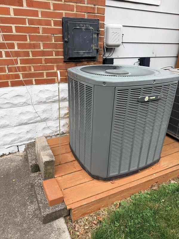 Completed HVAC estimate for replacement of existing 2-ton Trane system originally installed in 2009. Unit located in attic with access via second-floor ceiling requiring ladder access. Assessed current outdoor condenser positioned on wooden platform with brick wall mounting and evaluated replacement options for complete system upgrade.