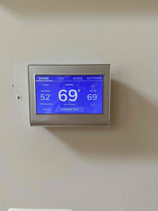 Performed comprehensive assessment of existing air conditioning system that is over 15 years old and currently not functioning properly. Evaluated existing air handler unit located in utility space and reviewed current thermostat operation displaying indoor temperature of 69° with outdoor conditions at 52°. Presented multiple replacement options for complete AC system upgrade to address failed equipment and provide improved cooling performance and efficiency for owner-occupied residence.