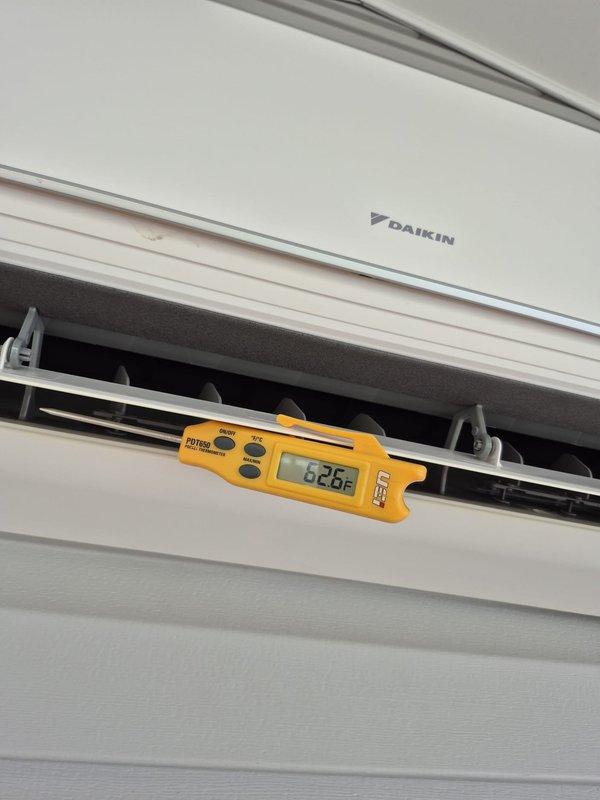 Performed cooling system maintenance check on Daikin wall-mounted mini-split unit. Verified system operation with thermostat set to 77°F in cooling mode with auto fan setting, measured supply air temperature at 62°F from evaporator discharge, confirming proper cooling performance and adequate temperature differential.