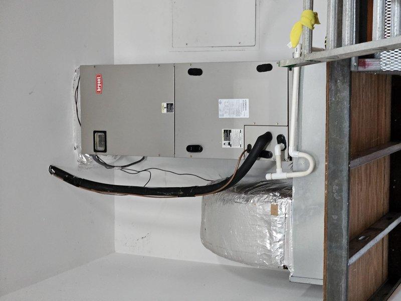 Completed estimate for complete HVAC system replacement including indoor air handler unit and outdoor condensing unit. Documented existing equipment configuration with indoor unit mounted on interior wall with refrigerant lines, condensate drain with proper trap, and connected ductwork plenum, along with outdoor rooftop-mounted condensing unit featuring cylindrical fan housing and condenser coil assembly.