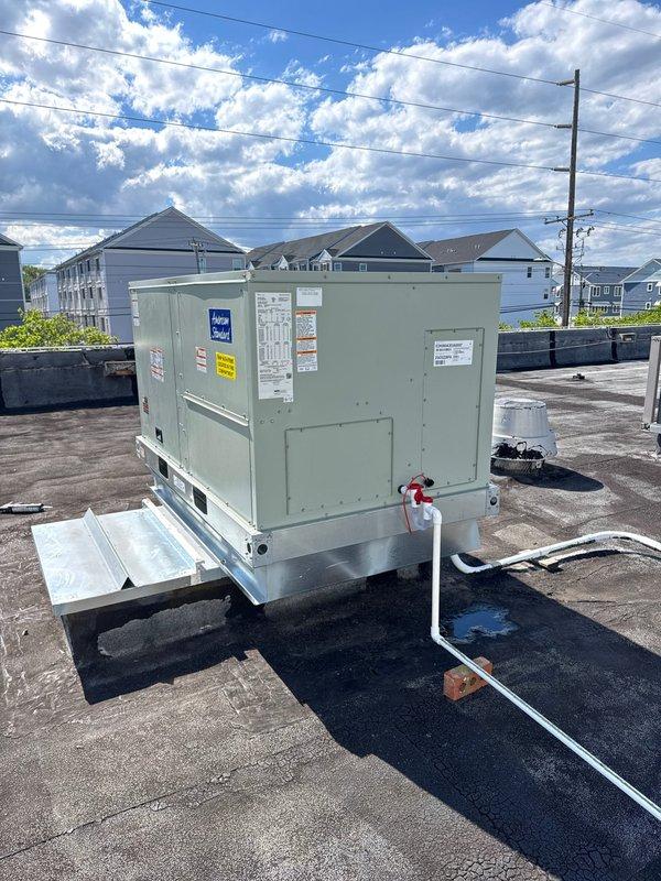 Completed full rooftop packaged unit replacement, removing and disposing of existing equipment. Installed American Standard EDK060A3E0A000 5-ton air conditioning unit with BAYHTFA320A 20KW heater package on new roof curb with proper adapter fittings. Fabricated and installed transition fittings to adapt new unit to existing trunk duct system. Crane service utilized for safe equipment removal and installation on commercial flat roof. Installed Honeywell TH6320WF WiFi thermostat for enhanced system control and remote access capabilities. All electrical connections, refrigerant lines, and ductwork transitions completed to manufacturer specifications. System tested and verified operational with proper airflow and temperature differential. One-year parts and labor warranty provided on complete new system installation.