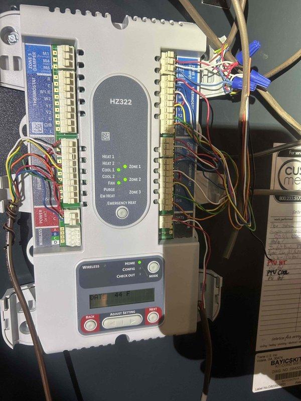 Completed preventative maintenance cooling system inspection on multi-zone HVAC system. Inspected and photographed HZ322 zone control panel with multiple heating and cooling zones, verified all indicator lights and digital display functionality, and checked terminal connections for proper wiring integrity. Inspected ductwork insulation and air handler unit in mechanical space, confirming proper installation and operation of flexible duct system with reflective insulation wrapping and reinforcement bands intact.