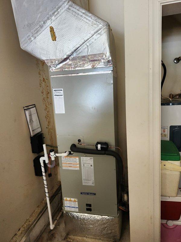 Completed full HVAC system replacement including removal and disposal of existing equipment. Installed American Standard 5A6H7048A1000 4-ton 17 SEER two-stage heat pump on plastic pad with snow legs per specifications. Mounted American Standard 5TEM6D06AV41S variable speed air handler in interior utility space with American Standard BAYHTR1517 15 kW electric heat pack and BAYSF1235 23.5" filter rack. Fabricated and installed metal duct transitions to adapt new equipment to existing ductwork. Replaced outdoor disconnect and electrical whip while reusing existing electrical service, condensation lines, and power lines where applicable. Installed Honeywell Digital WiFi Thermostat Elite Pro S1200 THX1200 for system control. Performed refrigerant charging and system startup procedures, verified proper operation using manifold gauges with system readings showing appropriate pressures and temperatures. System tested and confirmed operational with one-year parts and labor warranty from install