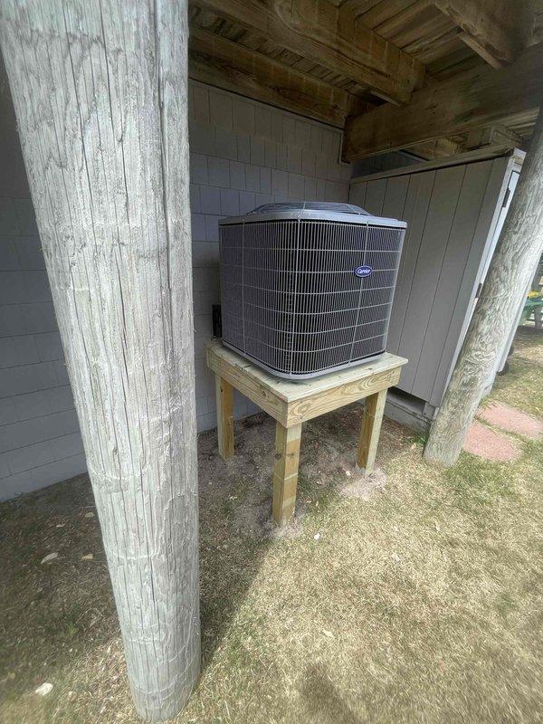 Completed full HVAC system replacement including removal and disposal of existing equipment. Installed new Carrier 27SCA536A003 3-ton 15 SEER heat pump outdoor unit on pressure-treated wood stand beneath covered porch area. Mounted Carrier FJ5ANXB36L00 air handling unit with ECM motor in interior utility space. Integrated Carrier 10kw electric heat pack for supplemental heating capacity. Fabricated and installed metal duct transitions to adapt new equipment to existing ductwork system. Reused existing refrigerant lines and condensate drainage. Replaced outdoor electrical disconnect and supply whip to meet current code requirements. Installed Honeywell digital WiFi thermostat for system control. Verified all electrical connections, refrigerant pressures, and airflow parameters. System tested and operational with one-year parts and labor warranty from installation date.