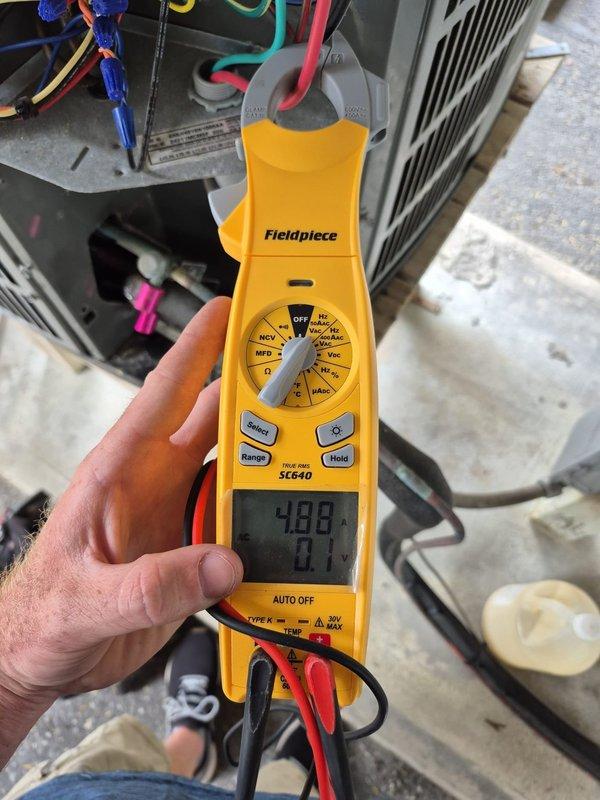 Performed cooling system maintenance including washing down the outdoor condensing unit to remove debris and restore proper airflow. Verified system operation with electrical diagnostics showing 426.5 volts and 7.1 amp draw, confirming equipment running within normal parameters. Thermostat set to cooling mode at 70 degrees with system cycling properly and maintaining desired temperature.